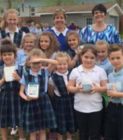 children and teachers smiling for the camera for the Seedlings for Schools program